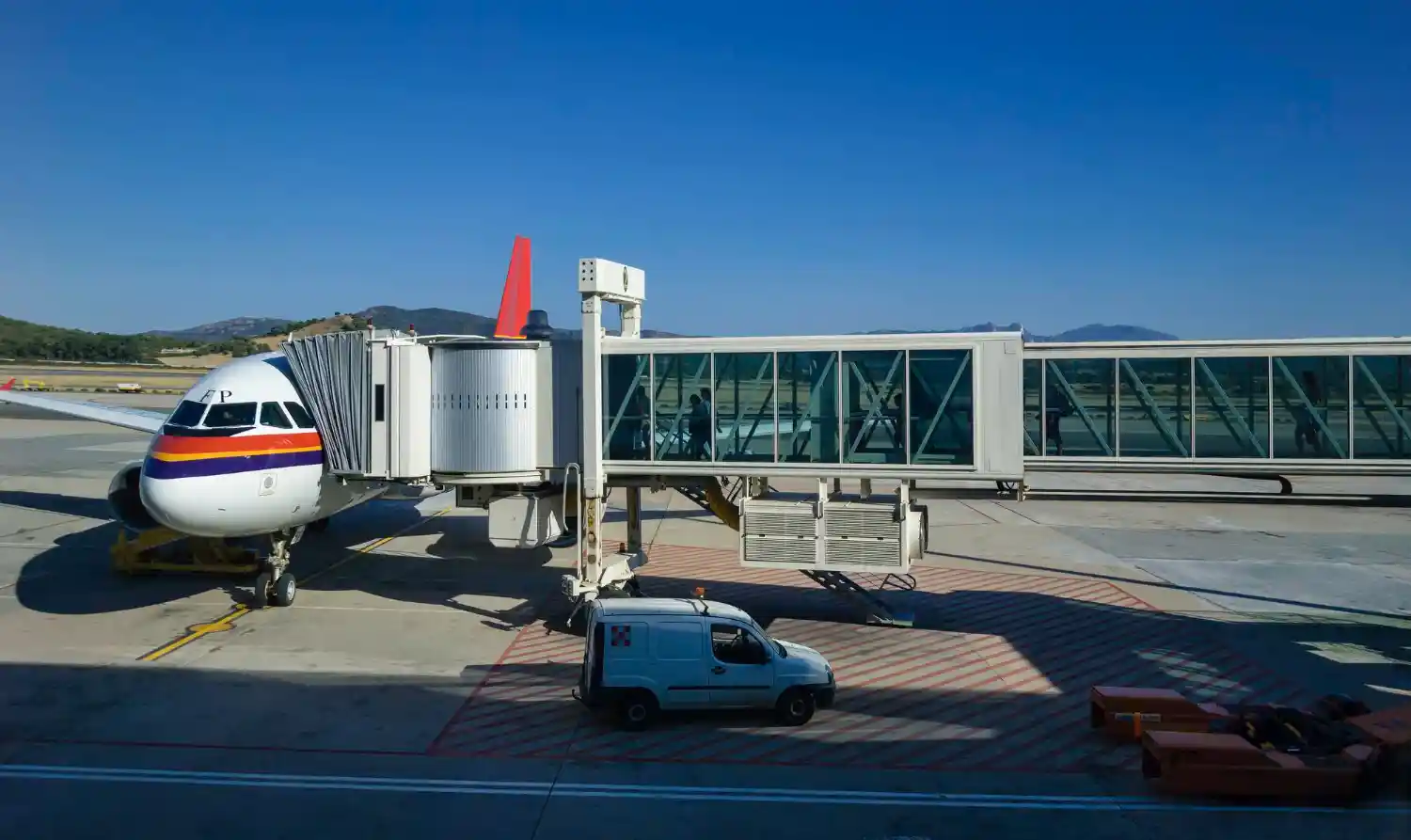 Gatwick Airport terminal drop-off zone showing £10 minimum charge system with ANPR cameras, payment notice signs, and free long stay parking shuttle service to North and South Terminals.